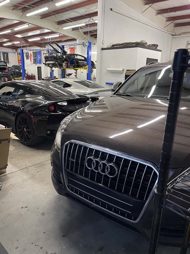 Brown Audi inside Euromotion service bay with other European vehicles in background
