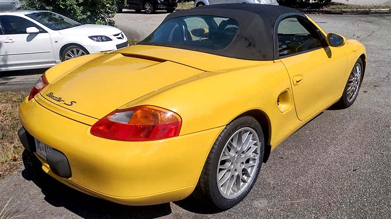 Yellow Porsche Boxster rear three-quarter view