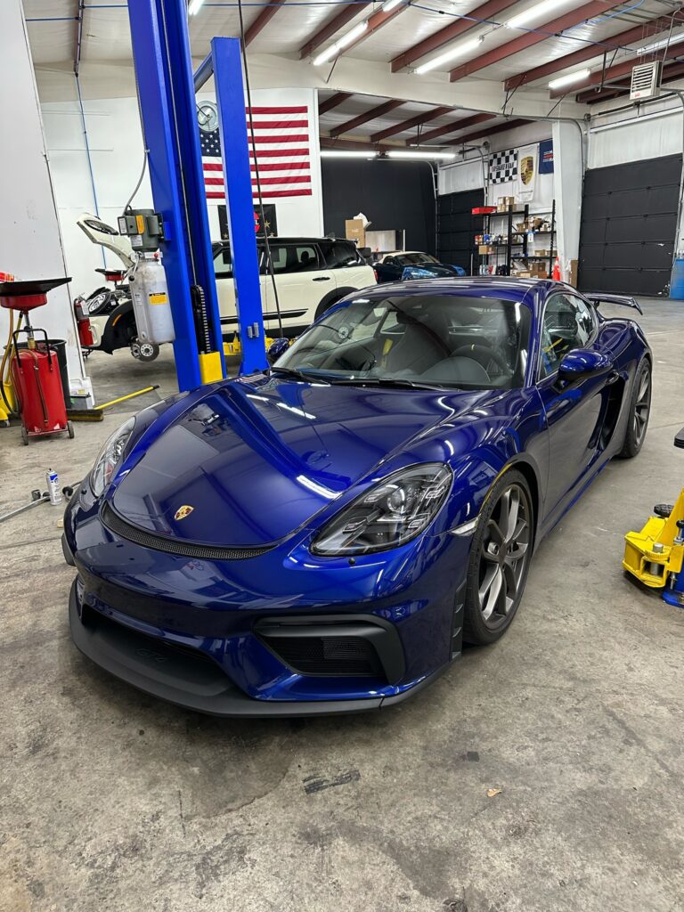 Blue Porsche 718 Cayman GT4 inside the Euromotion shop