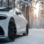 White Mercedes-Benz AMG driving on a snowy road