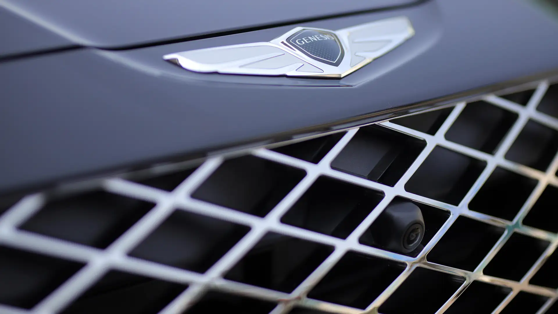 Close-up of the Genesis emblem and signature front grille