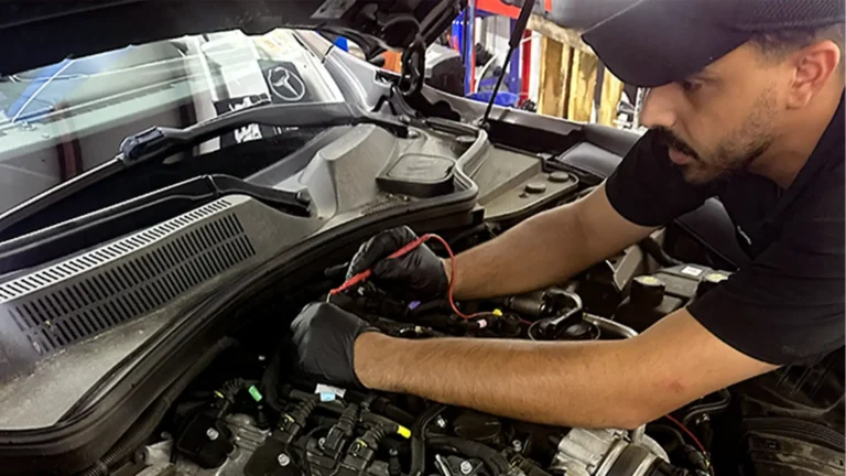 Euromotion technician testing electrical components in a vehicle engine bay
