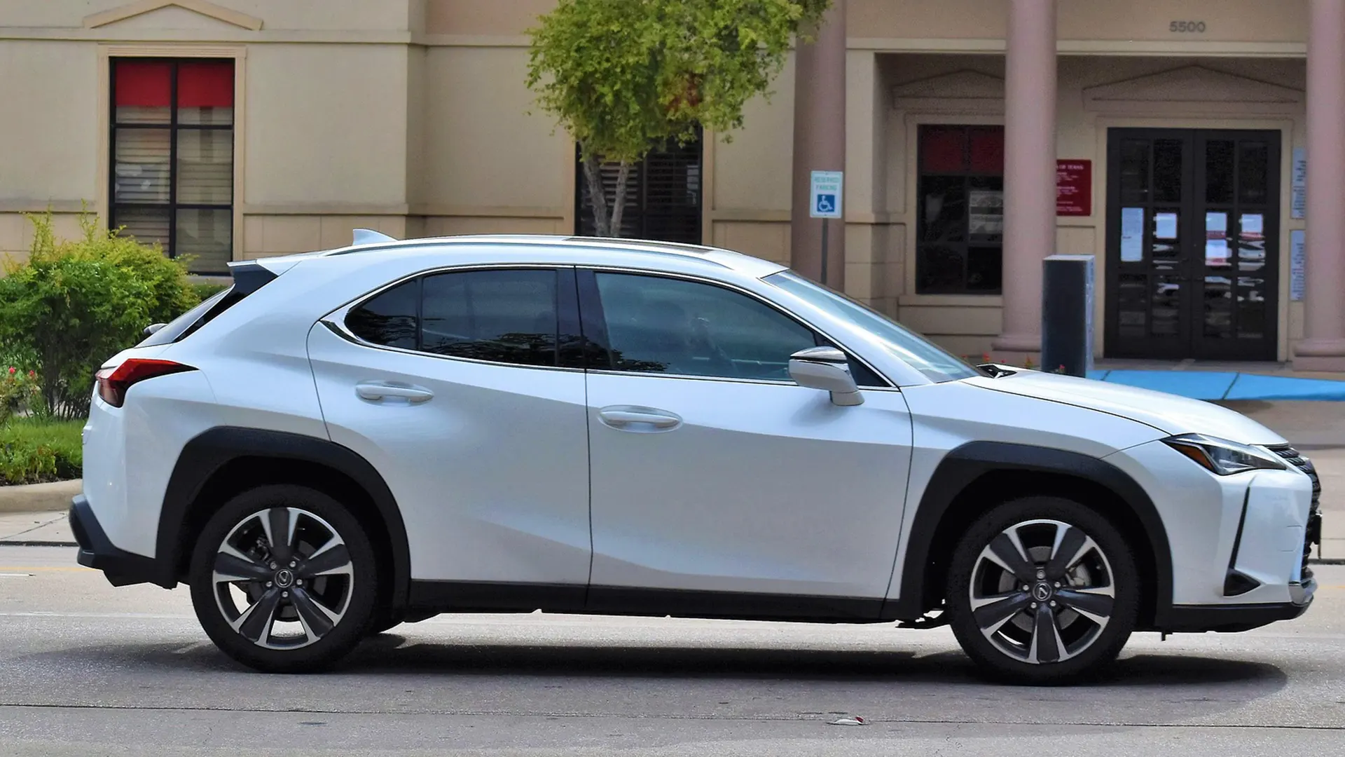 White Lexus SUV driving on a city street